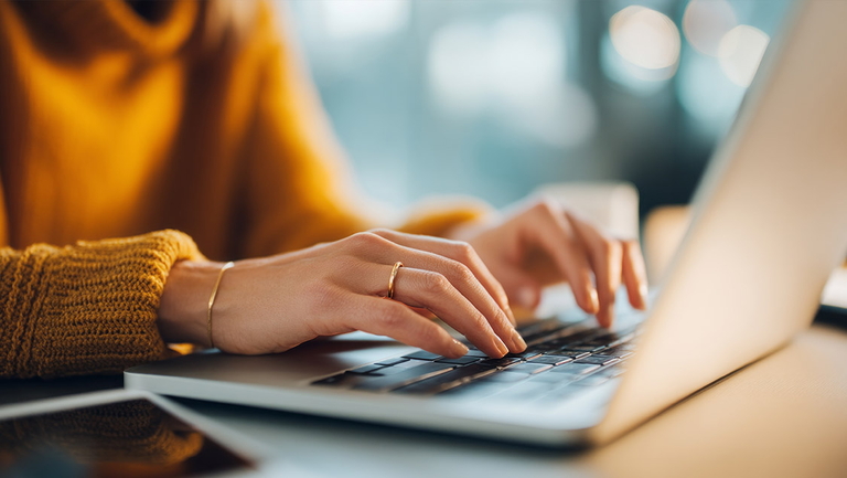 Jemand arbeitet konzentriert am Laptop in gemütlicher Atmosphäre