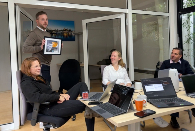 ESYON team members celebrate the Gold Partner award in a meeting.