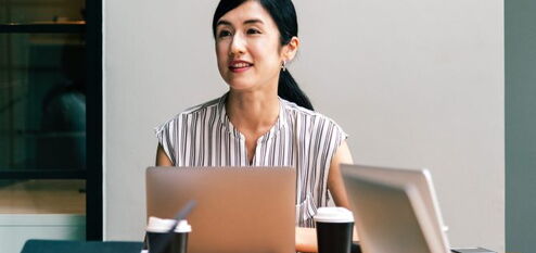 Person sitting in front of a laptop at a conference table