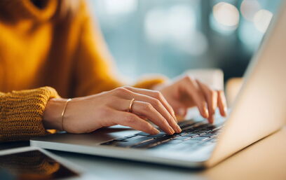 Jemand arbeitet konzentriert am Laptop in gemütlicher Atmosphäre