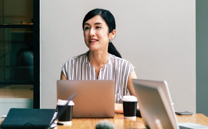 Person sitting in front of a laptop at a conference table